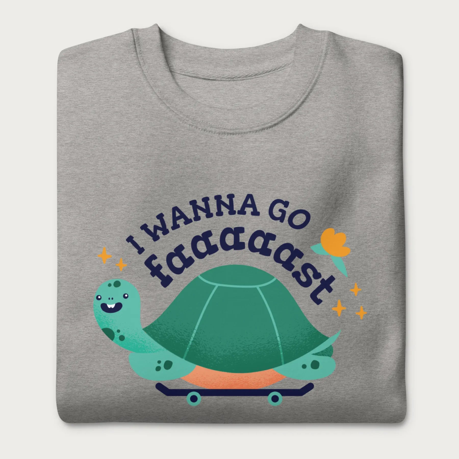 Folded light grey sweatshirt with a graphic of a turtle on a skateboard and the phrase 'I Wanna Go Fast.'