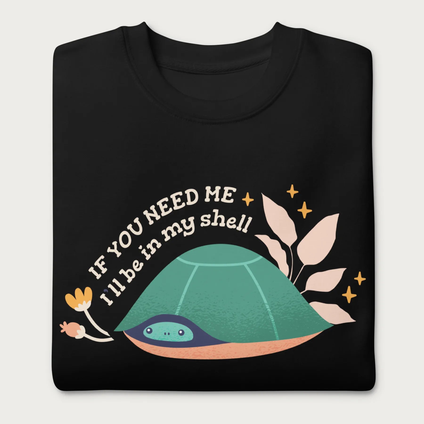 Folded black sweatshirt with a graphic of a turtle hiding in its shell and the phrase 'If You Need Me, I'll Be in My Shell.'