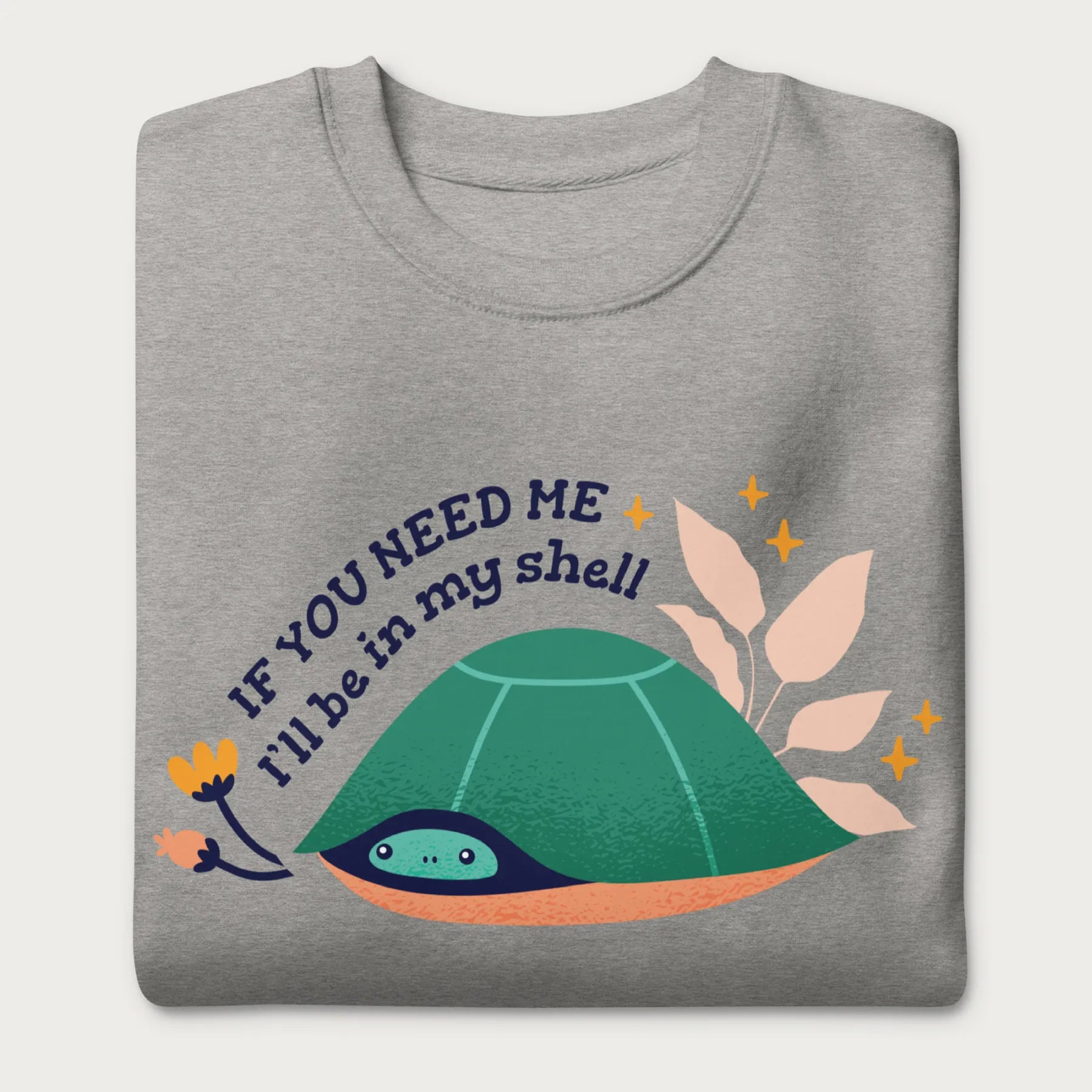 Folded light grey sweatshirt with a graphic of a turtle hiding in its shell and the phrase 'If You Need Me, I'll Be in My Shell.'