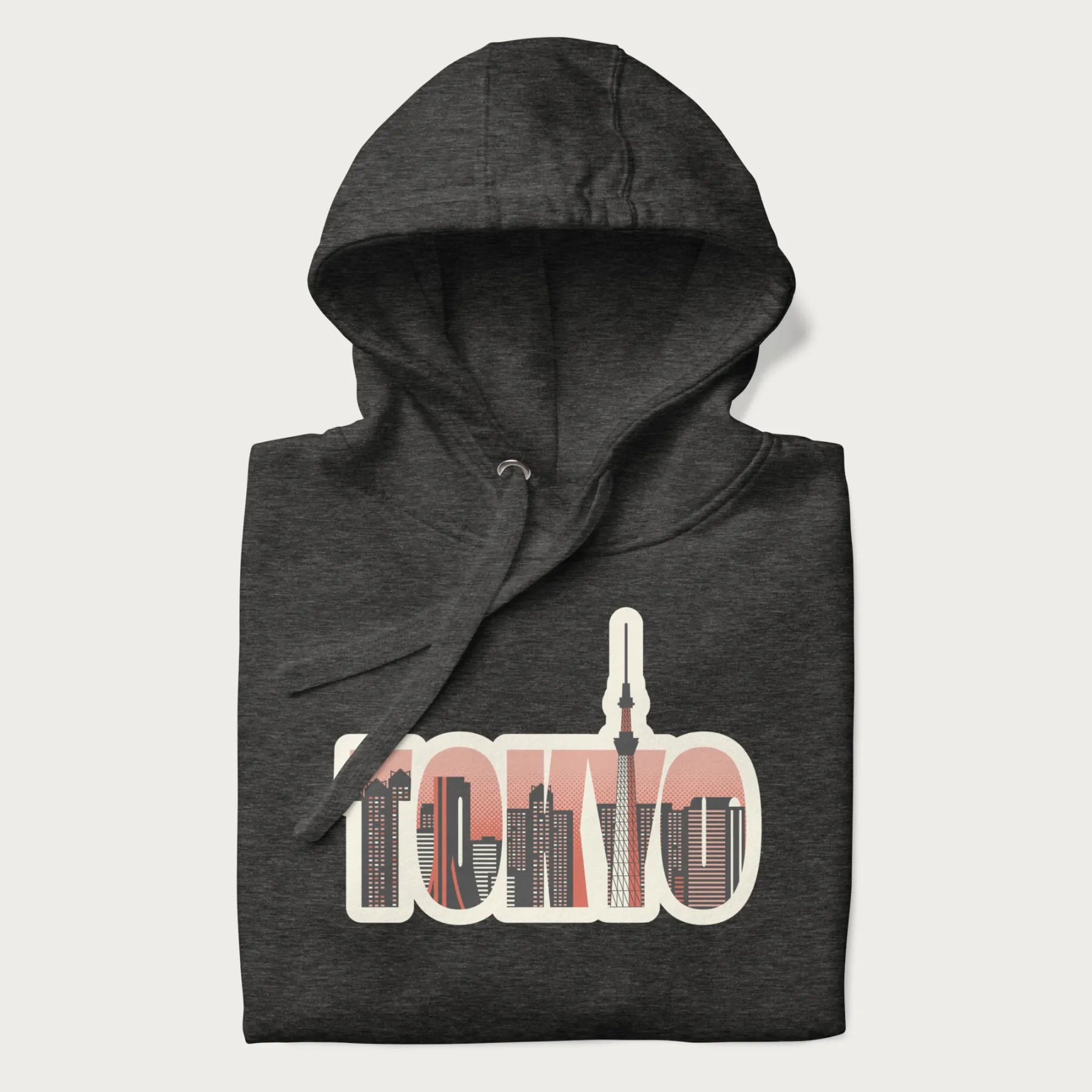 Folded dark grey hoodie with graphic of Tokyo's skyline integrated into the word 'TOKYO' in sunset colors.