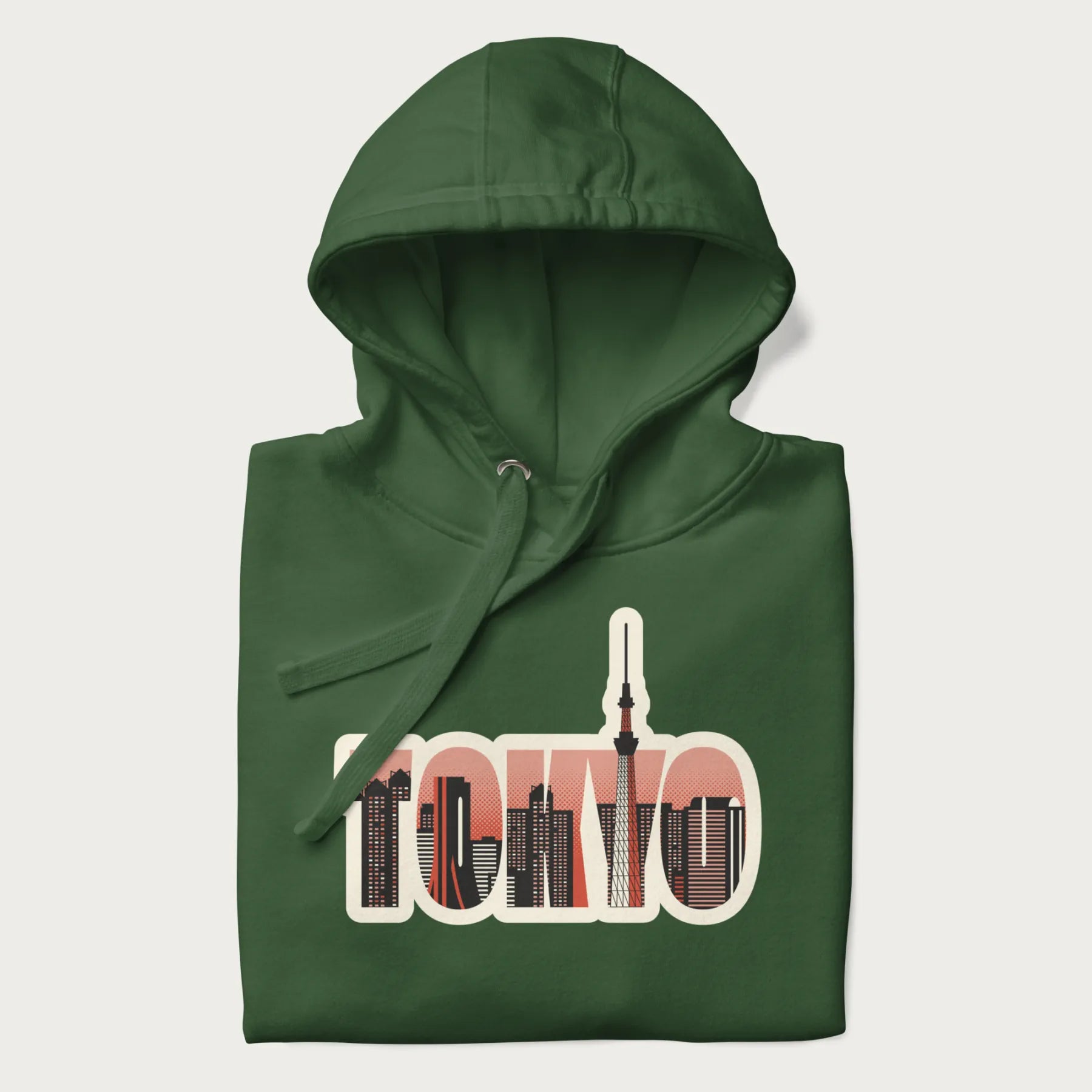 Folded forest green hoodie with graphic of Tokyo's skyline integrated into the word 'TOKYO' in sunset colors.