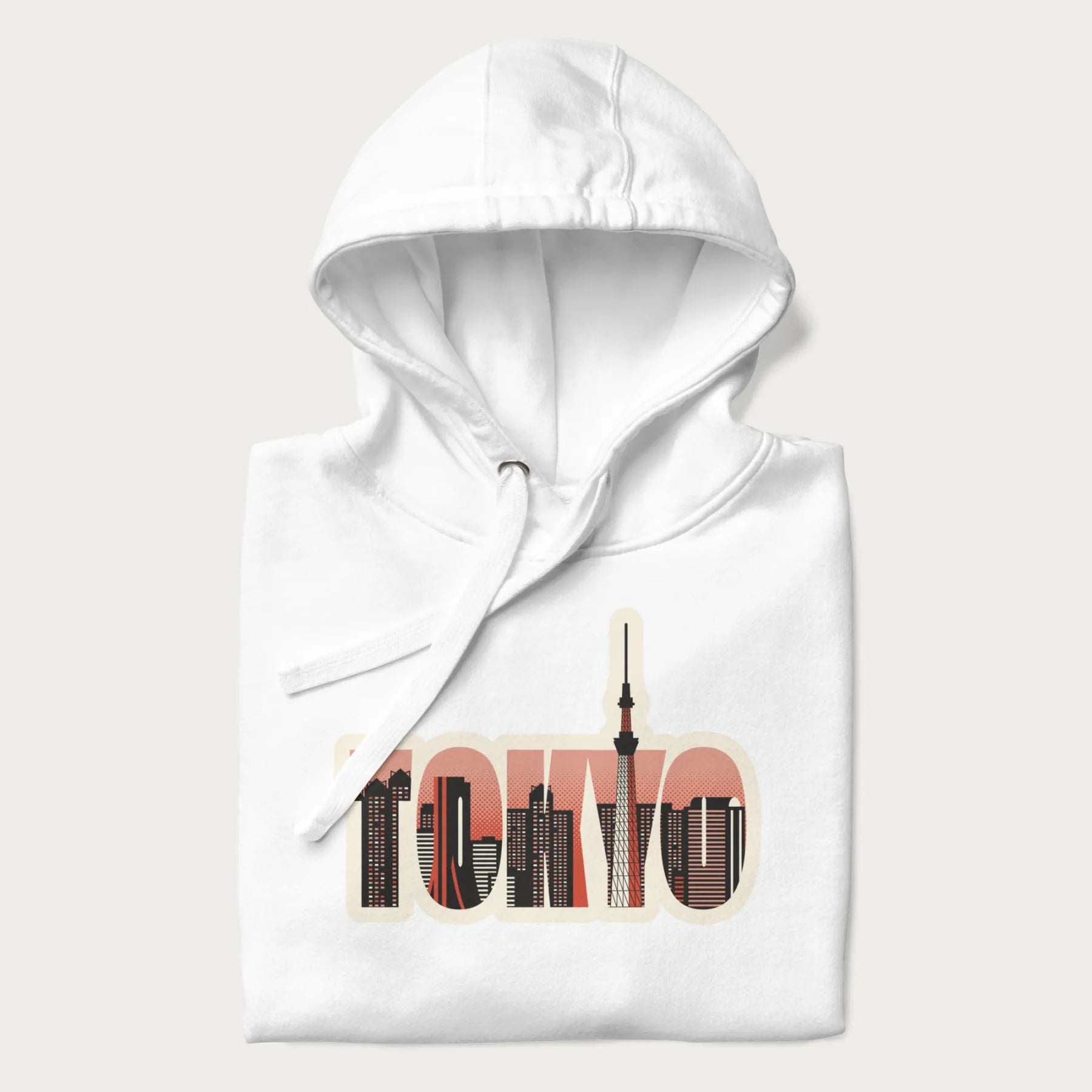 Folded white hoodie with graphic of Tokyo's skyline integrated into the word 'TOKYO' in sunset colors.