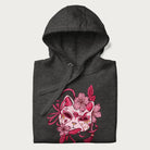 Folded dark grey hoodie with a Japanese kitsune mask and sakura design on the front.
