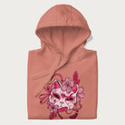 Folded light pink hoodie with a Japanese kitsune mask and sakura design on the front.