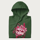 Folded green hoodie with a Japanese kitsune mask and sakura design on the front.