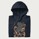 Folded navy blue hoodie with Japanese text and a graphic of an eagle battling a snake, with the text 'Tokyo Japan' underneath.