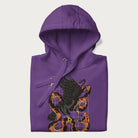Folded purple hoodie with Japanese text and a graphic of an eagle battling a snake, with the text 'Tokyo Japan' underneath.