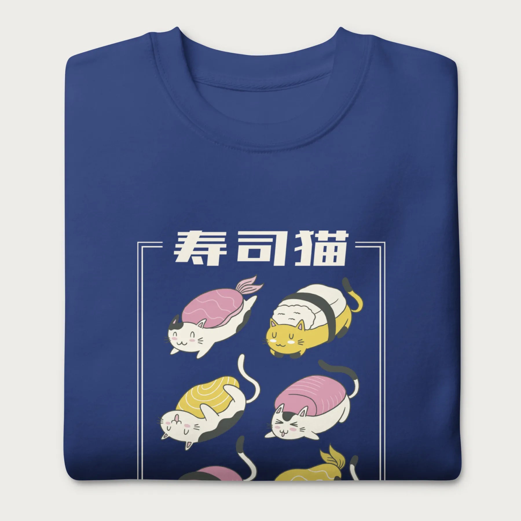 Folded royal blue sweatshirt with Japanese text and graphic of cats disguised as sushi.