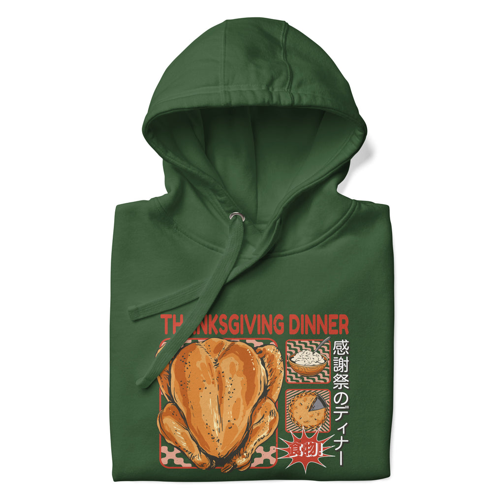 Folded Japanese Thanksgiving Hoodie in Forest Green color: A deep forest green hoodie adorned with a graphic print illustrating a Japanese Thanksgiving celebration, complete with a roast chicken, Japanese potato salad, and an apple pie. The hoodie is neatly folded.
