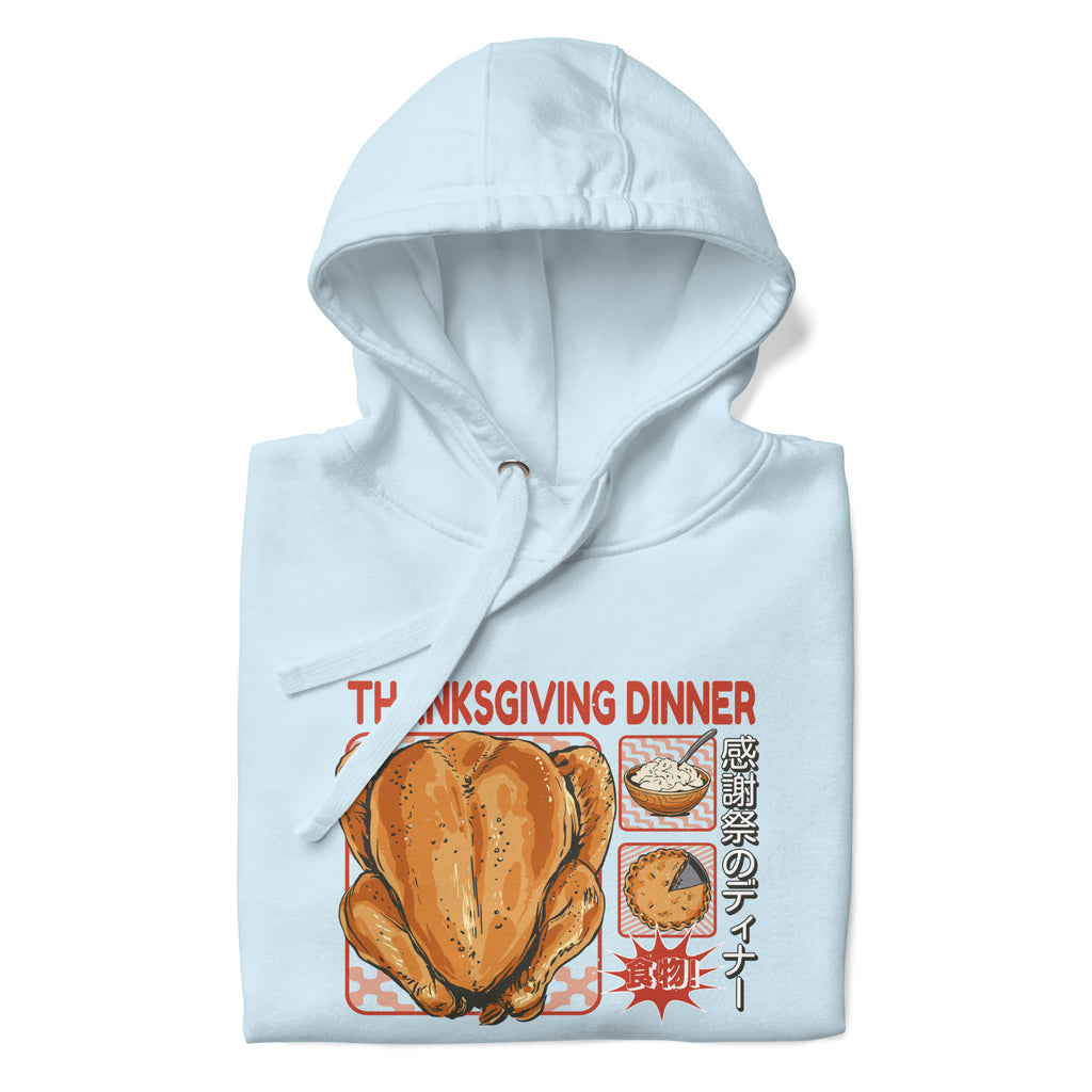 Folded Japanese Thanksgiving Hoodie in Sky Blue color: A light and refreshing sky blue hoodie adorned with a graphic of a Japanese Thanksgiving celebration, complete with a roast chicken, Japanese potato salad, and an apple pie. The hoodie is neatly folded.