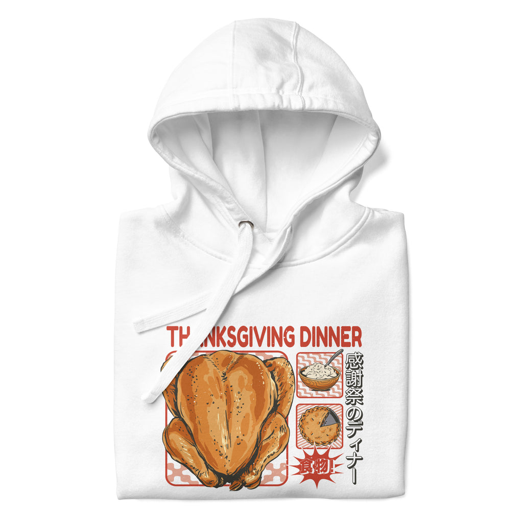 Folded Japanese Thanksgiving Hoodie in White color: A crisp white hoodie featuring a graphic print of a Japanese Thanksgiving, including a roast chicken, Japanese potato salad, and an apple pie. The hoodie is neatly folded.