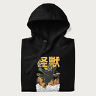 Folded black hoodie with graphic of a 'Kaiju Cat' with helicopters and flames in a burning city.