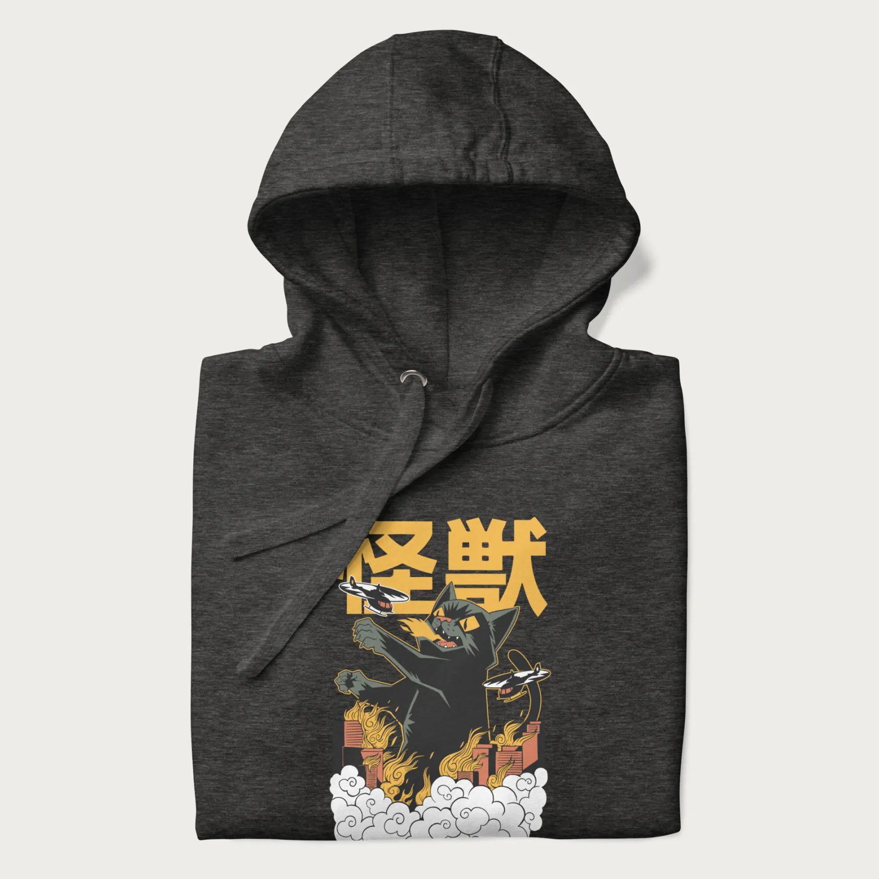 Folded dark grey hoodie with graphic of a 'Kaiju Cat' with helicopters and flames in a burning city.