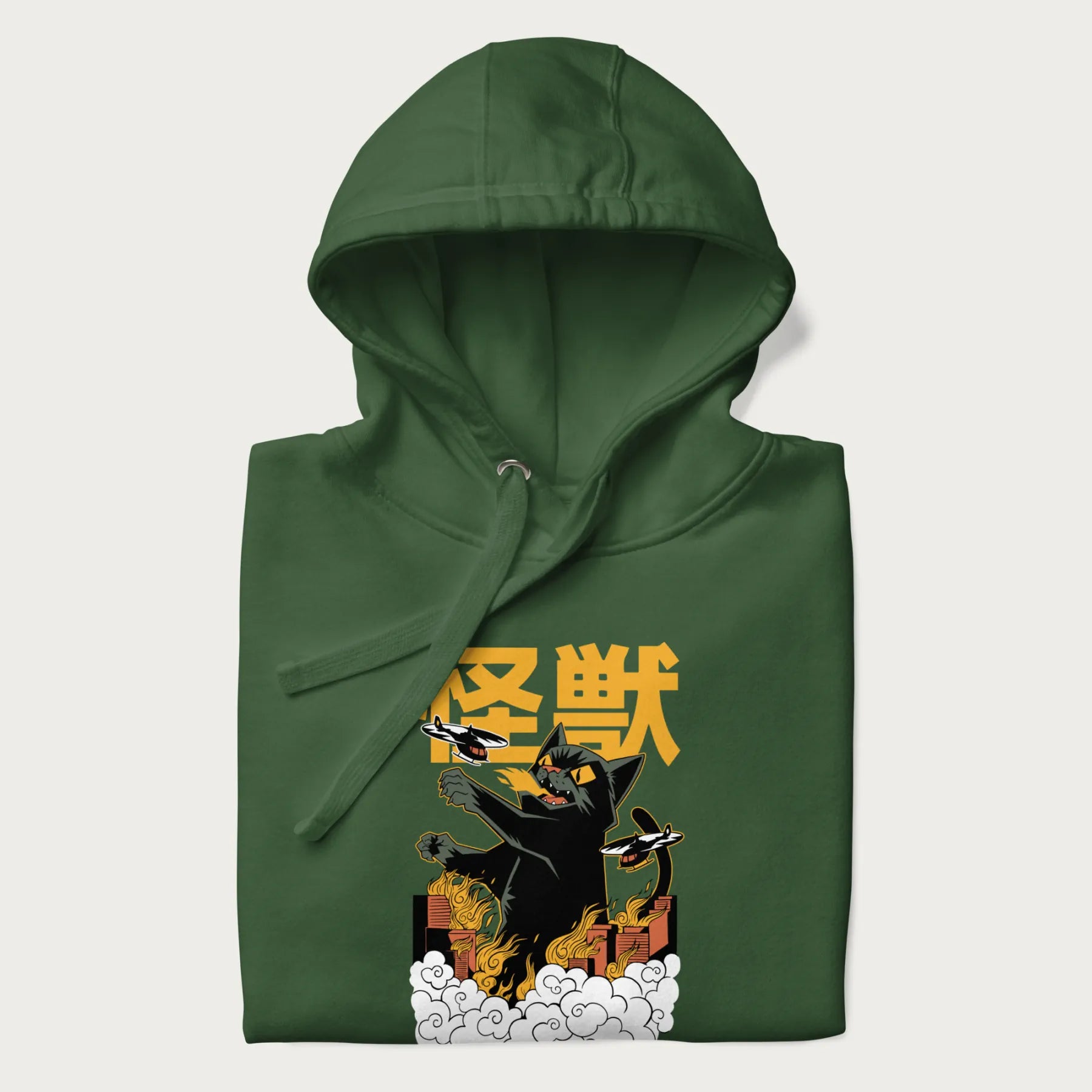 Folded forest green hoodie with graphic of a 'Kaiju Cat' with helicopters and flames in a burning city.