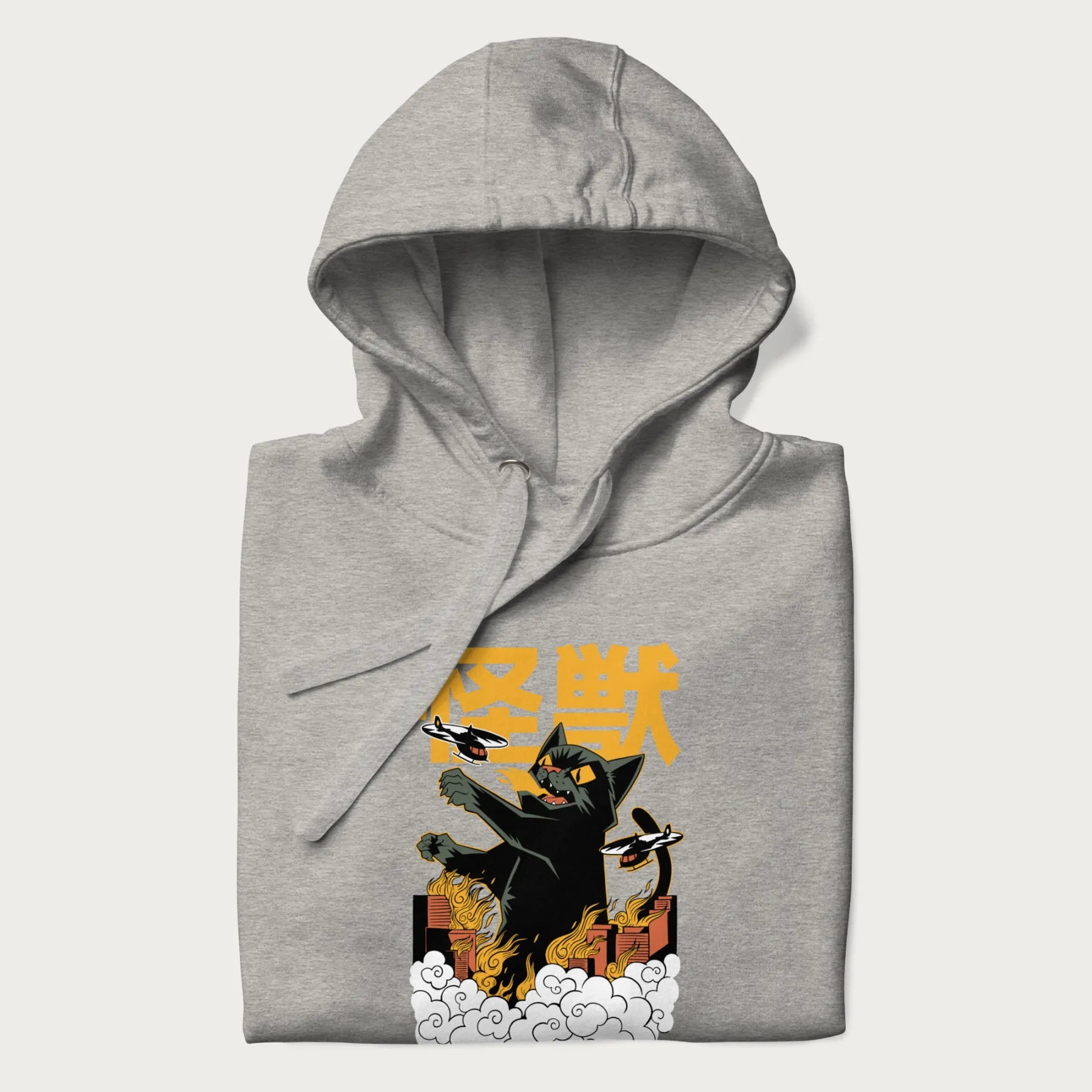Folded light grey hoodie with graphic of a 'Kaiju Cat' with helicopters and flames in a burning city.