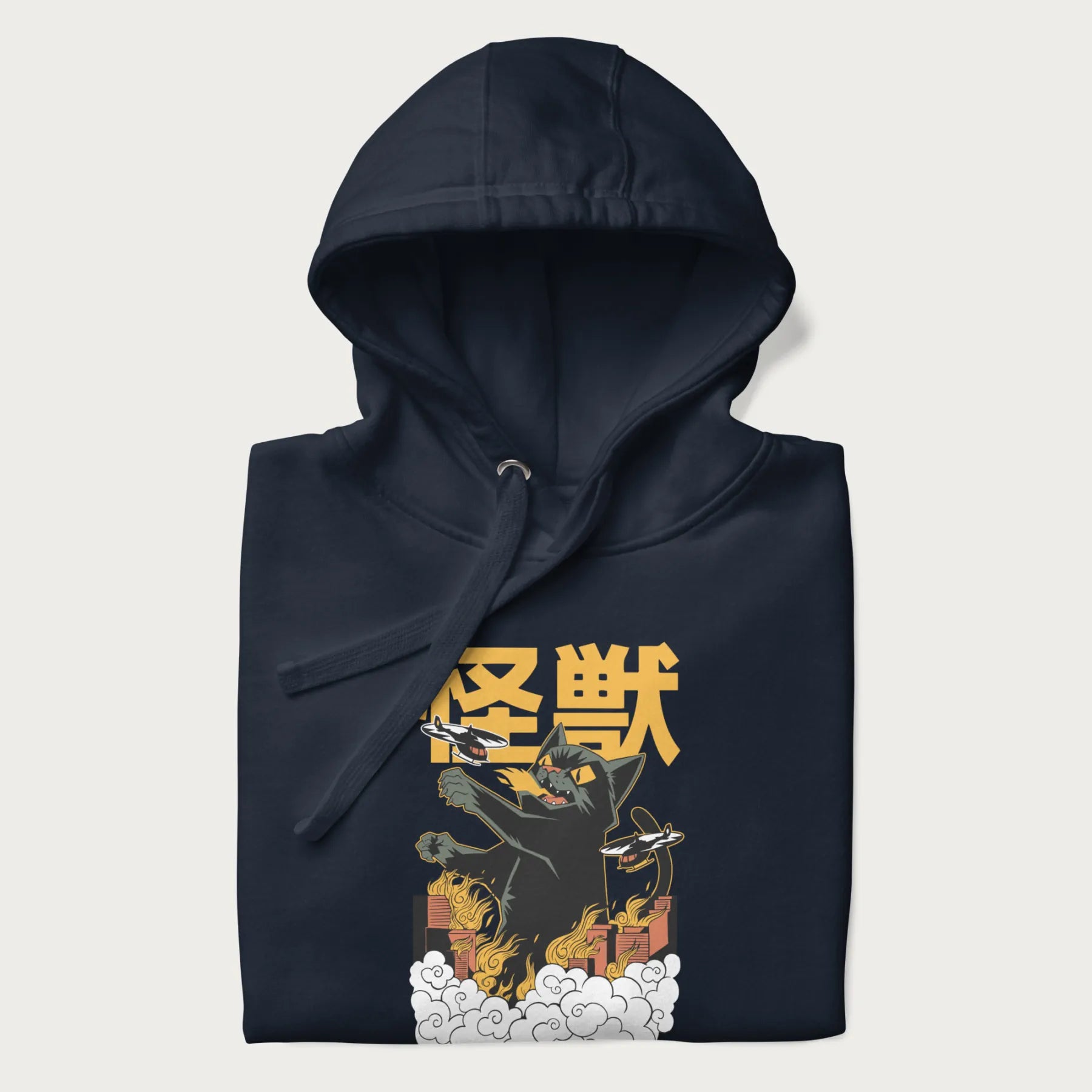 Folded navy blue hoodie with graphic of a 'Kaiju Cat' with helicopters and flames in a burning city.