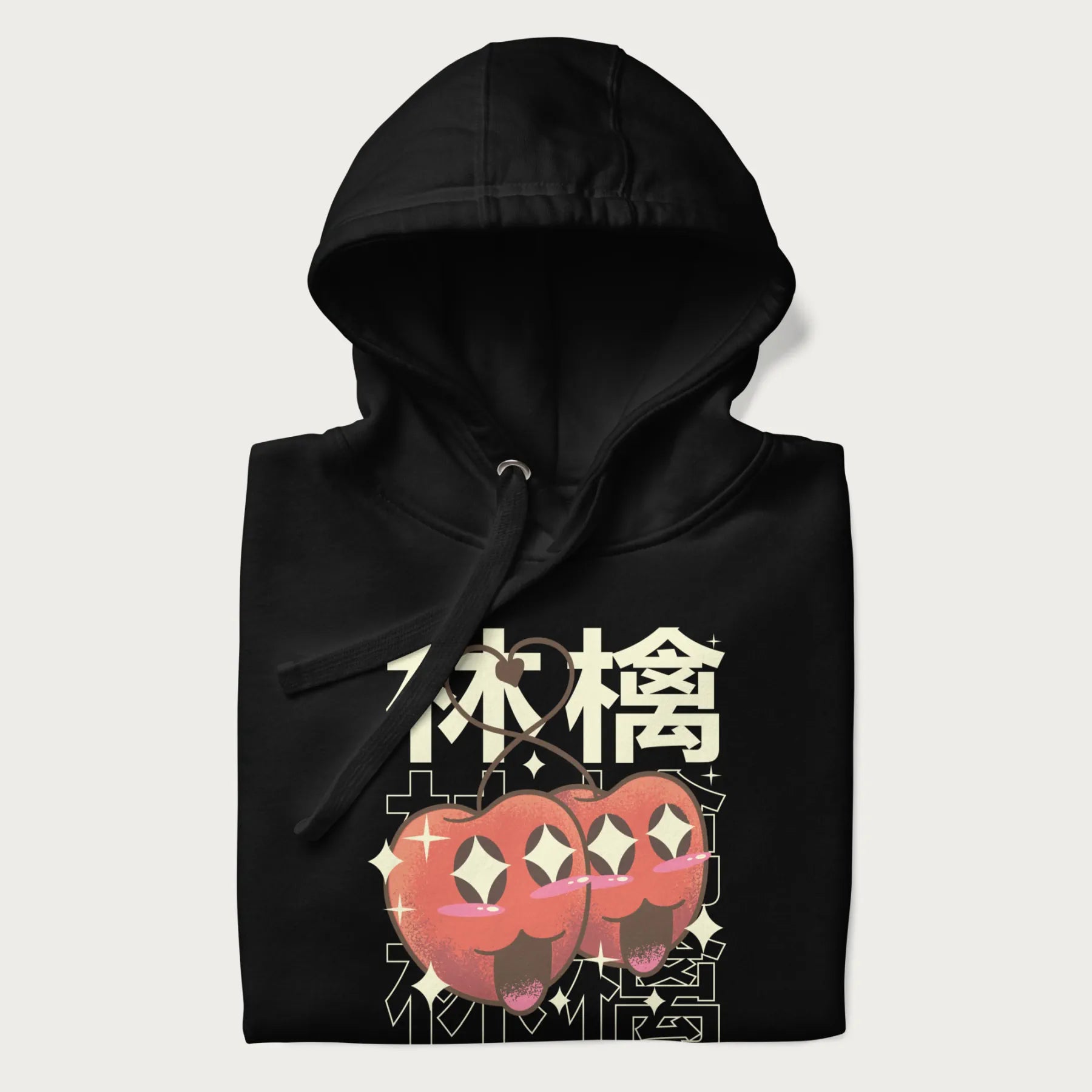 Folded black hoodie with Japanese graphic of two cute apples with kawaii faces, surrounded by the Japanese text '林檎' (Apple)