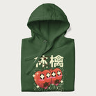 Folded forest green hoodie with Japanese graphic of two cute apples with kawaii faces, surrounded by the Japanese text '林檎' (Apple)