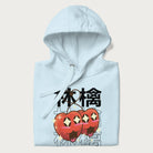 Folded light blue hoodie with Japanese graphic of two cute apples with kawaii faces, surrounded by the Japanese text '林檎' (Apple)