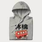 Folded light grey hoodie with Japanese graphic of two cute apples with kawaii faces, surrounded by the Japanese text '林檎' (Apple)