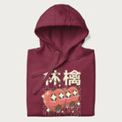 Folded maroon hoodie with Japanese graphic of two cute apples with kawaii faces, surrounded by the Japanese text '林檎' (Apple)