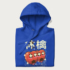 Folded royal blue hoodie with Japanese graphic of two cute apples with kawaii faces, surrounded by the Japanese text '林檎' (Apple)