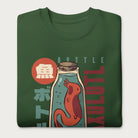 Folded forest green sweatshirt with a vintage graphic of an axolotl in a glass bottle with bold Japanese text.