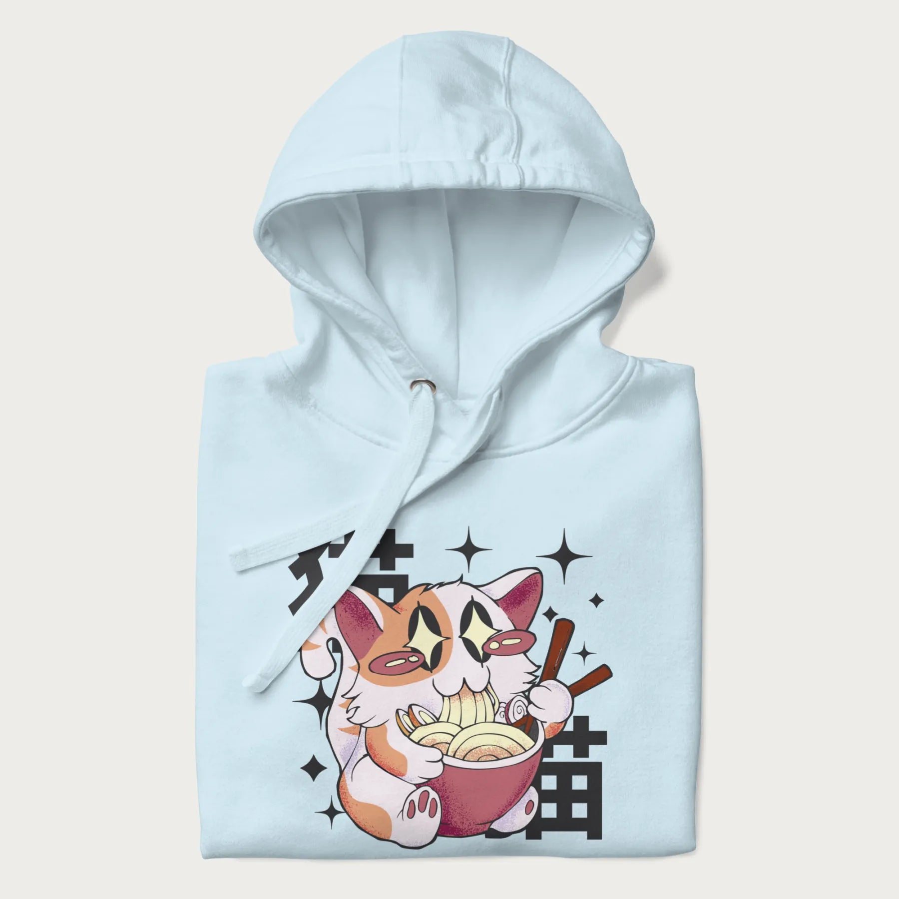 Folded light blue hoodie with Japanese graphic of a cat eating ramen with Japanese text '猫' in the background.