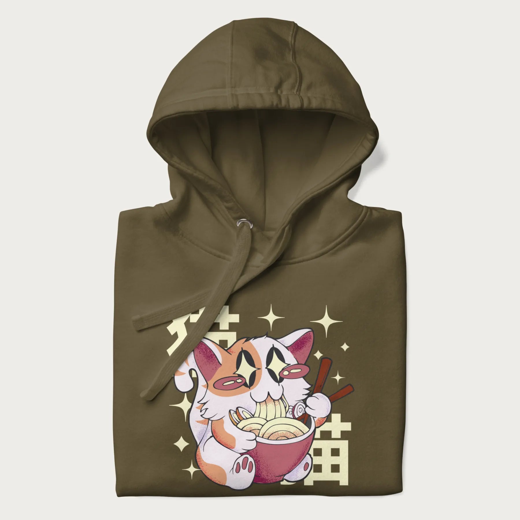 Folded military green hoodie with Japanese graphic of a cat eating ramen with Japanese text '猫' in the background.