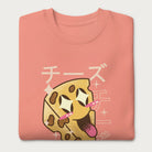 Folded light pink sweatshirt with Japanese text and a kawaii cheese wedge graphic.