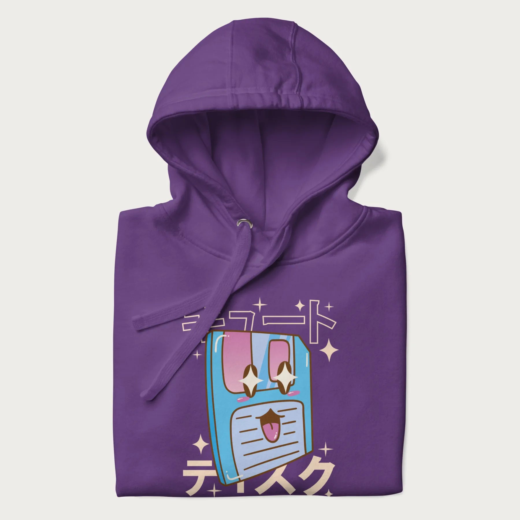 Folded purple hoodie with Japanese graphic of a cute sky-blue floppy disk with Japanese text 'キュート' (Cute) and 'ティスク' (Disk).