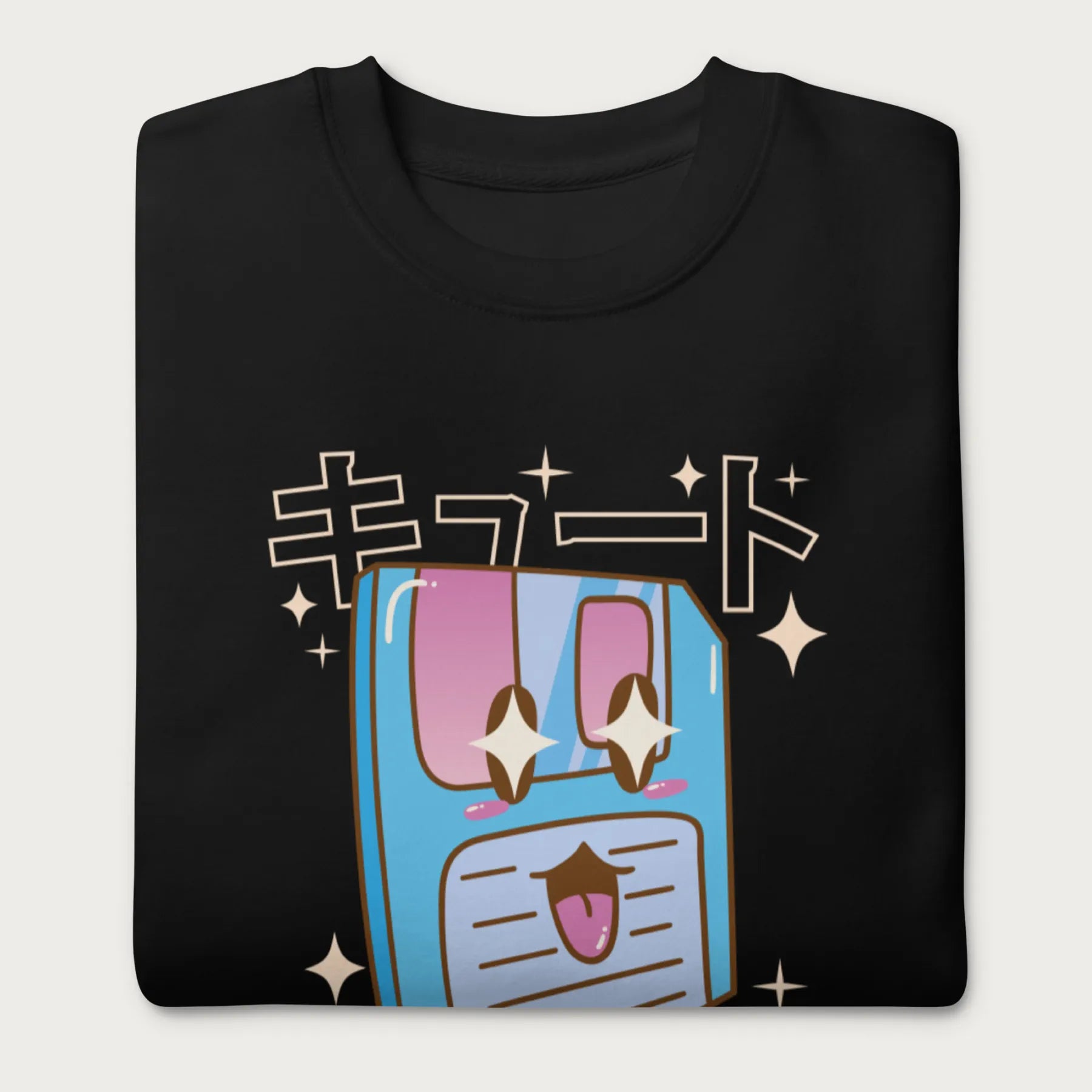 Folded black sweatshirt with a kawaii floppy disk graphic in vibrant colors and Japanese text.