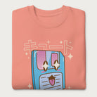 Folded light pink sweatshirt with a kawaii floppy disk graphic in vibrant colors and Japanese text.