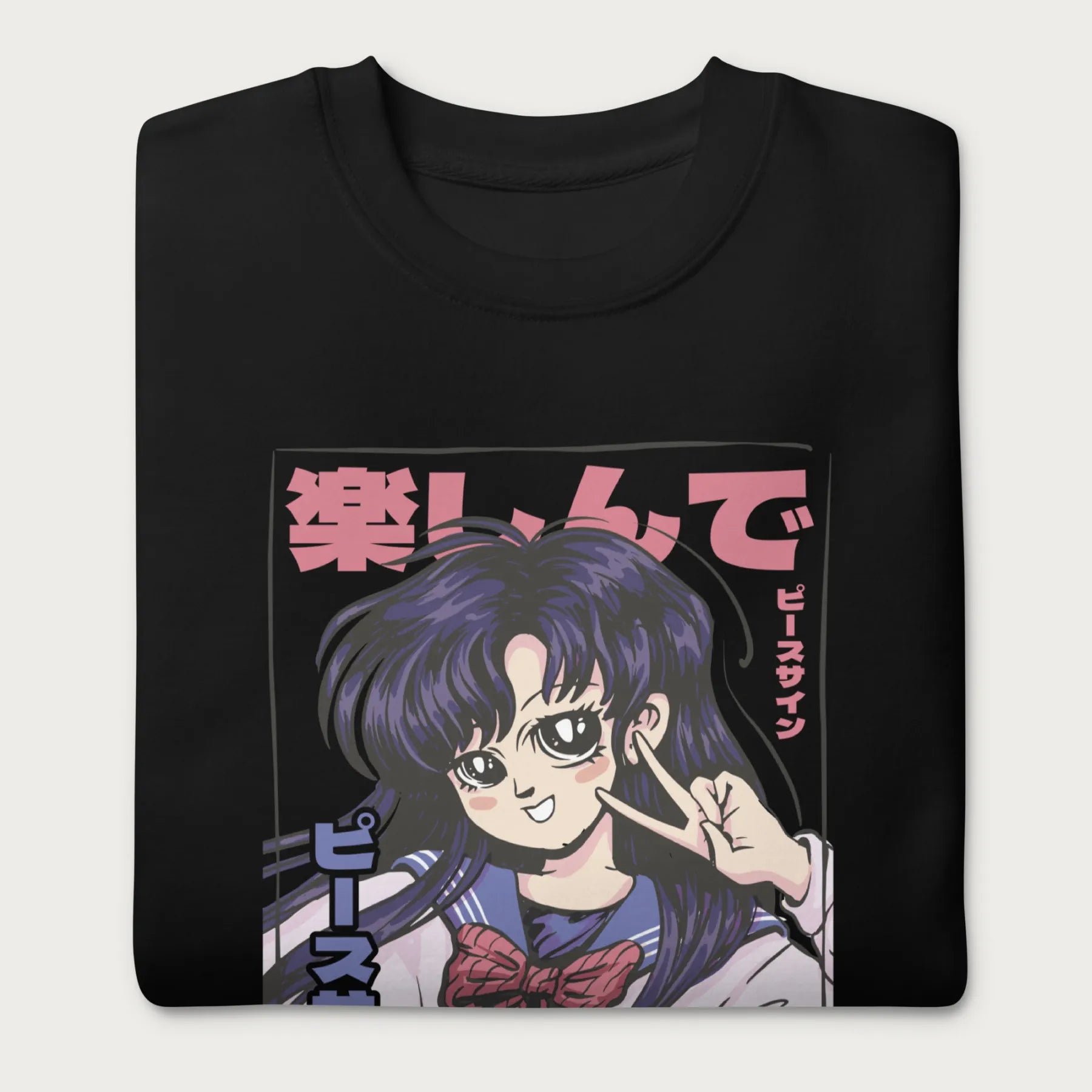 Folded black sweatshirt with a vibrant graphic of an anime girl flashing a peace sign with bold Japanese text.