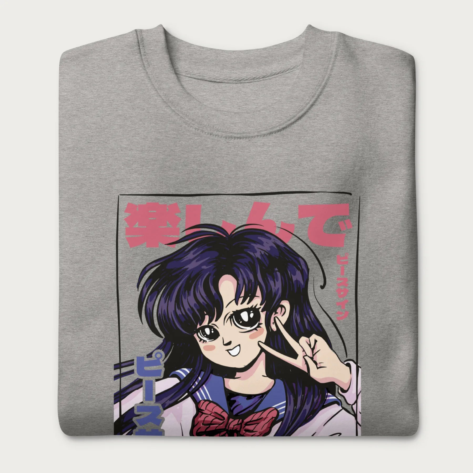 Folded light grey sweatshirt with a vibrant graphic of an anime girl flashing a peace sign with bold Japanese text.