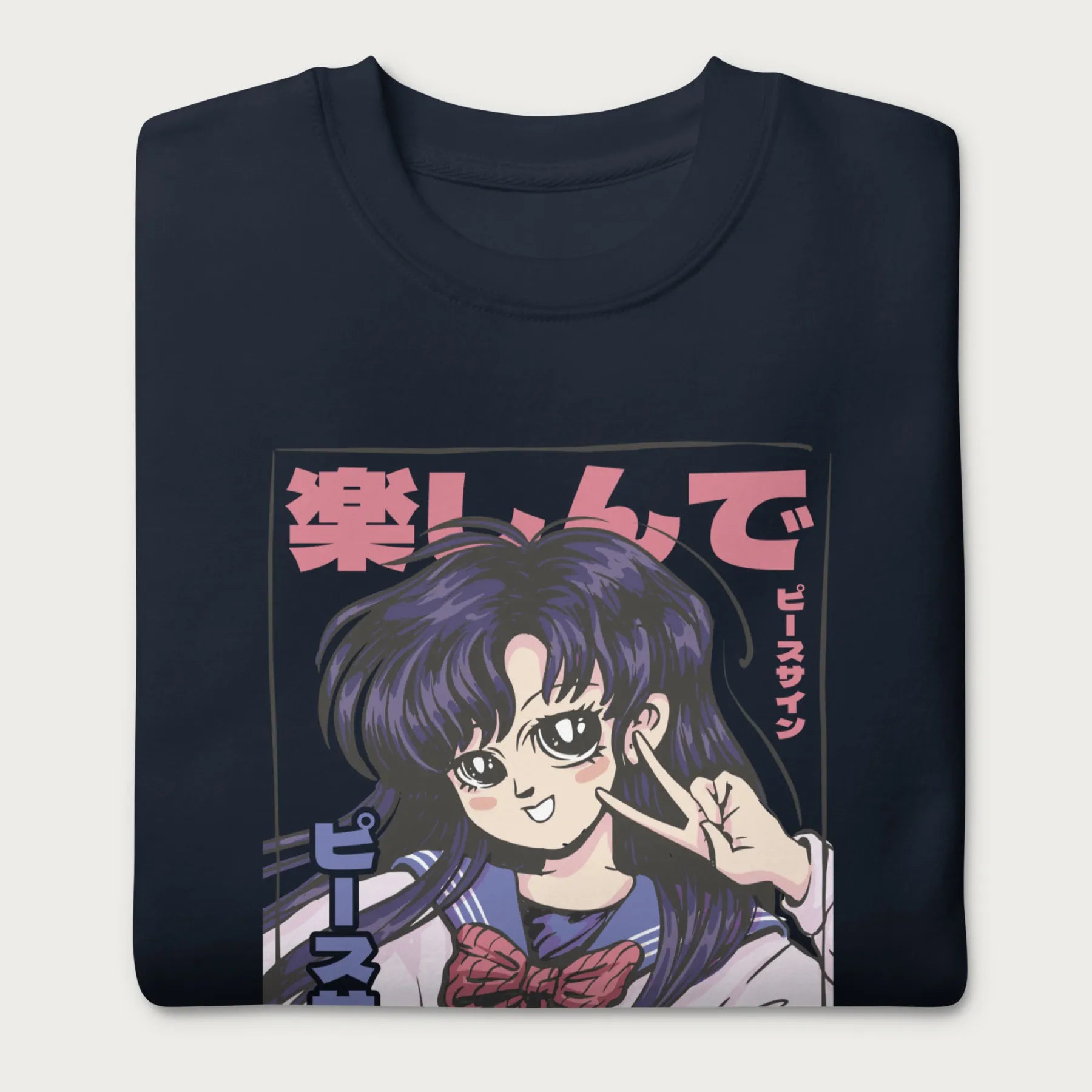 Folded navy blue sweatshirt with a vibrant graphic of an anime girl flashing a peace sign with bold Japanese text.