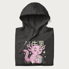 Folded dark grey hoodie with Japanese graphic of a cute pink axolotl sipping strawberry milk from a carton, with Japanese text '苺牛乳' (Strawberry Milk).