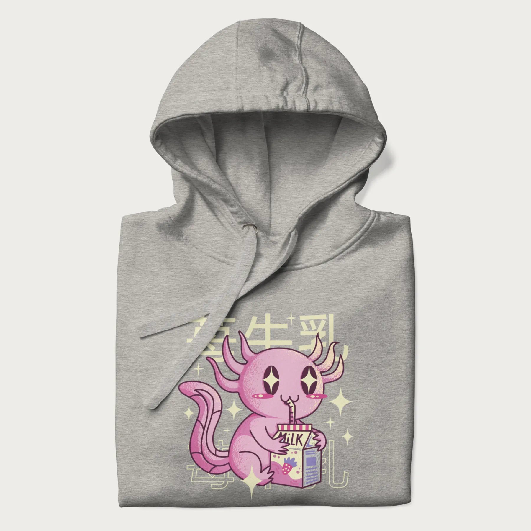 Folded light grey hoodie with Japanese graphic of a cute pink axolotl sipping strawberry milk from a carton, with Japanese text '苺牛乳' (Strawberry Milk).