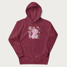 Maroon hoodie with Japanese graphic of a cute pink axolotl sipping strawberry milk from a carton, with Japanese text '苺牛乳' (Strawberry Milk).