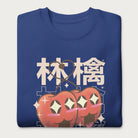 Folded royal blue sweatshirt with Japanese text and a kawaii red apple graphic.