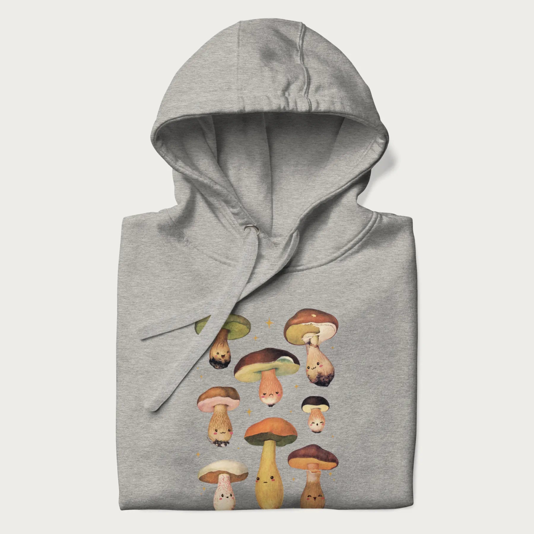 Folded light grey hoodie with Japanese graphic of cute and expressive mushrooms with various faces.