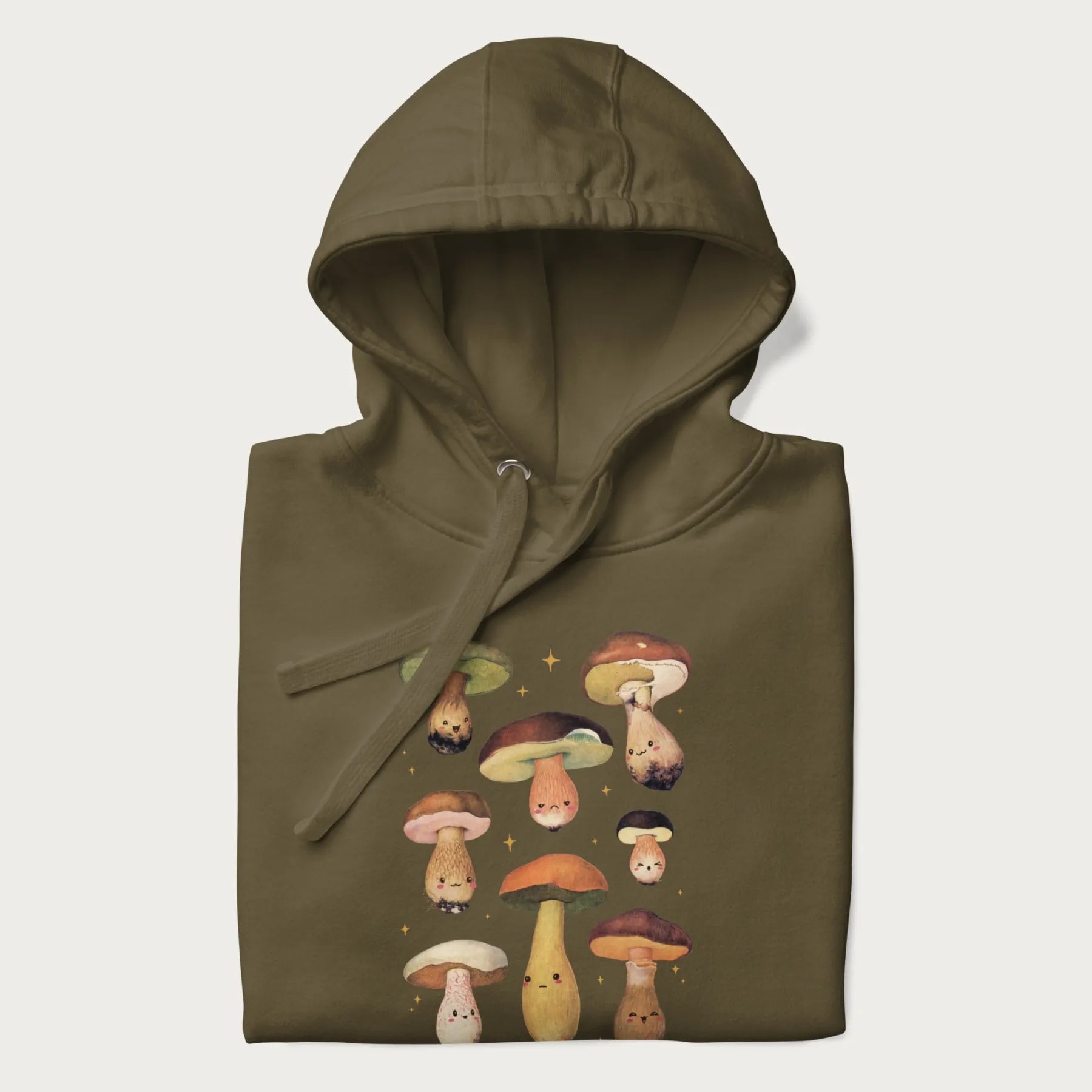 Folded military green hoodie with Japanese graphic of cute and expressive mushrooms with various faces.