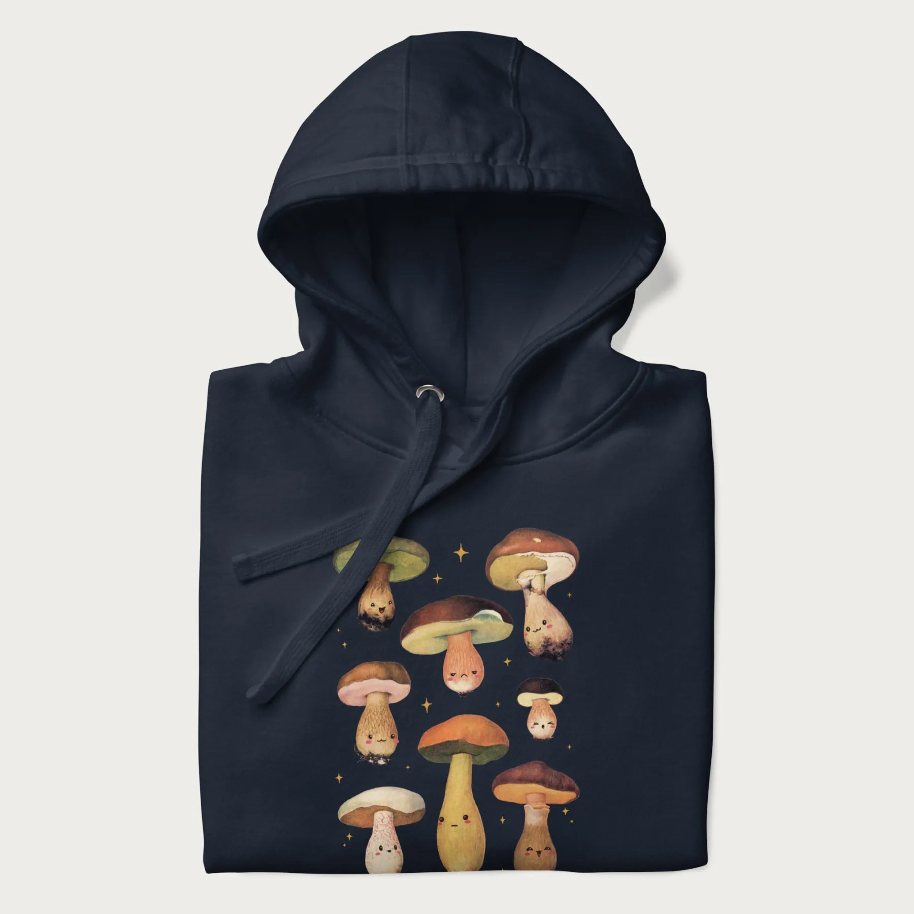 Folded navy blue hoodie with Japanese graphic of cute and expressive mushrooms with various faces.