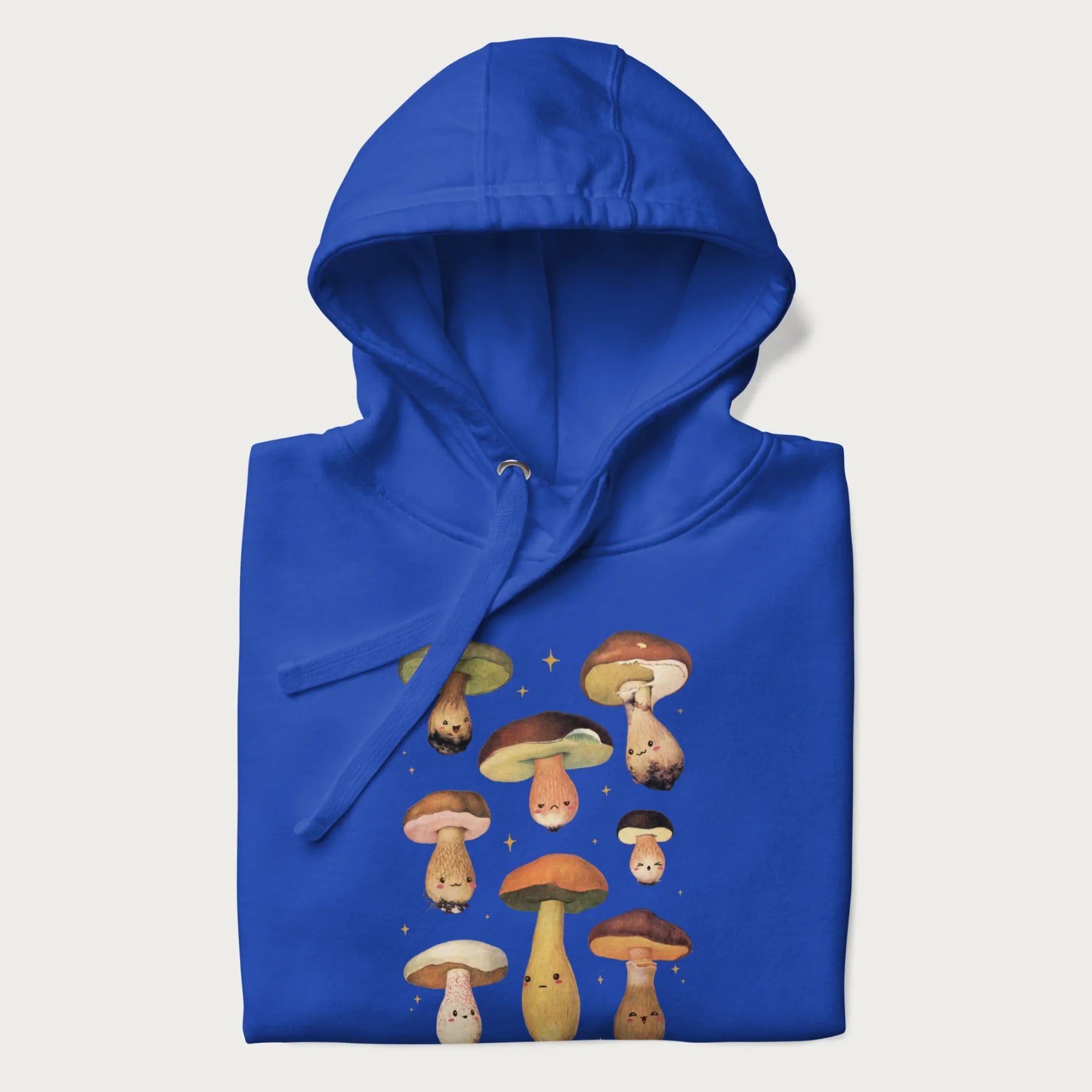 Folded royal blue hoodie with Japanese graphic of cute and expressive mushrooms with various faces.