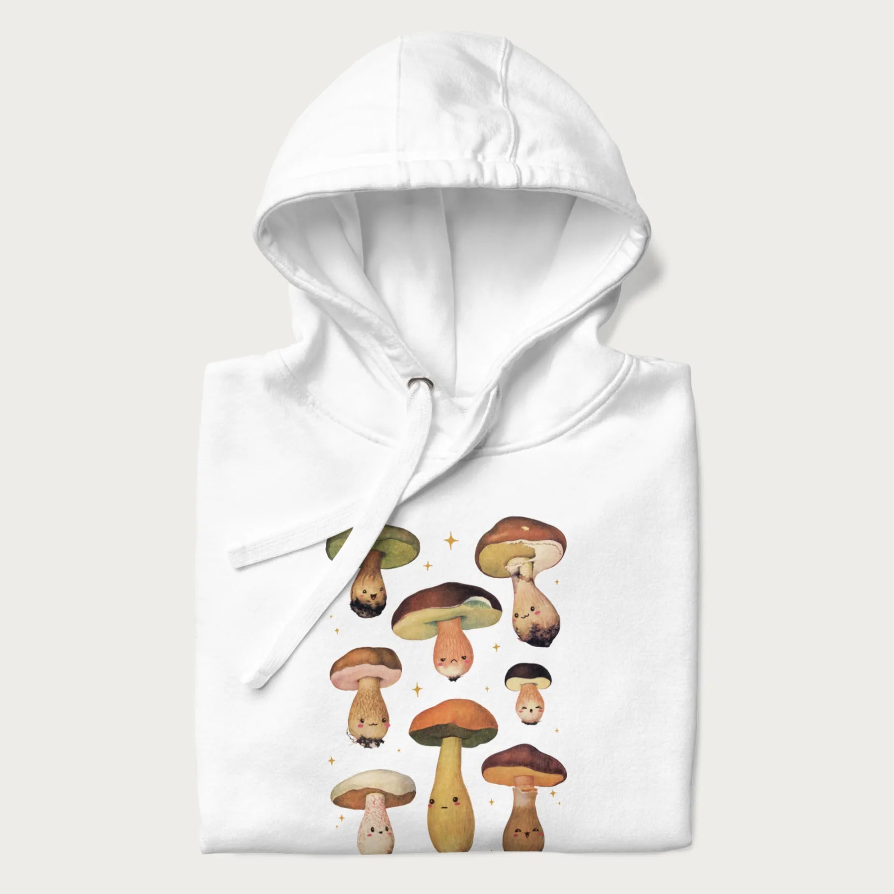 Folded white hoodie with Japanese graphic of cute and expressive mushrooms with various faces.