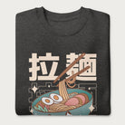 Folded dark grey sweatshirt with Japanese text and a kawaii ramen bowl graphic.