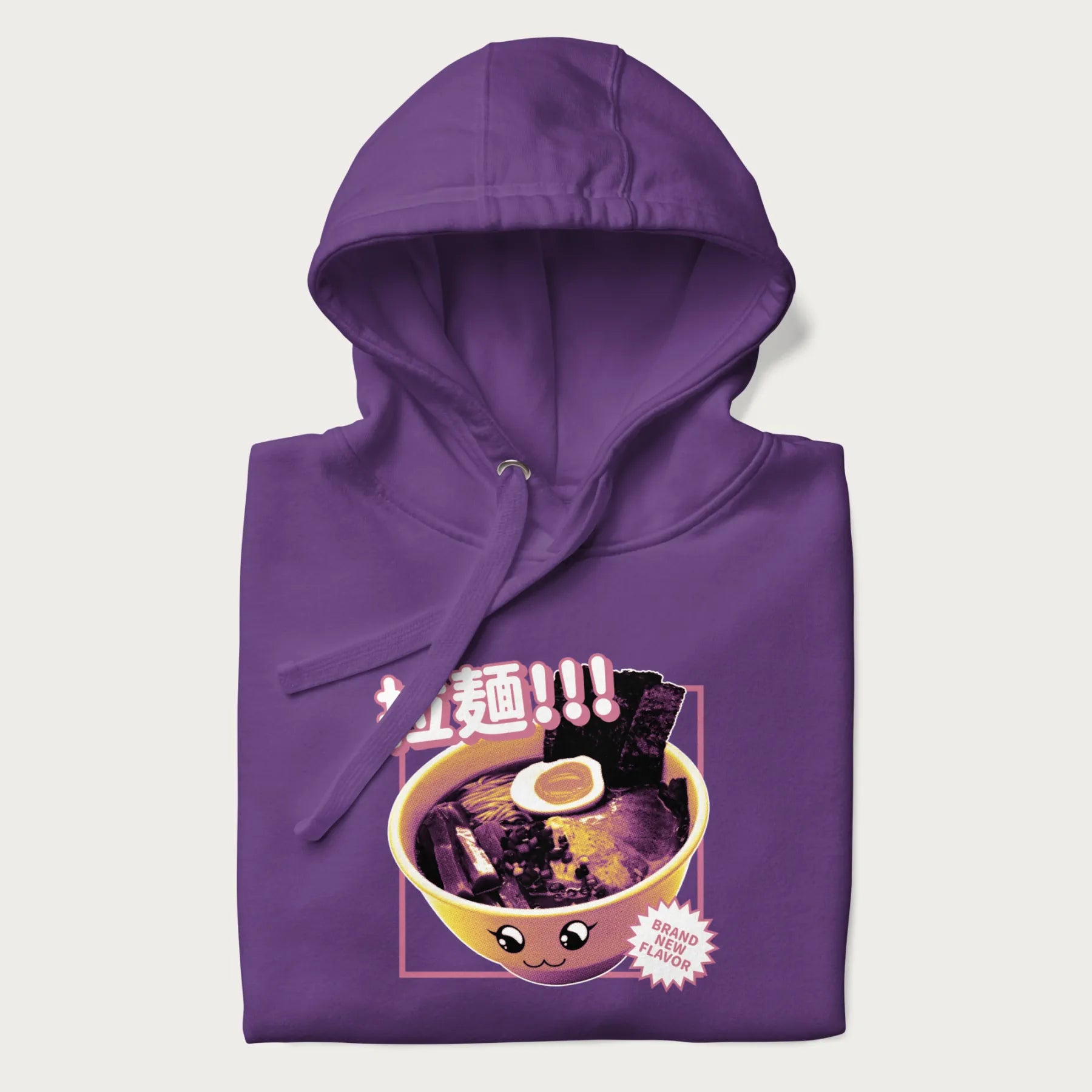 Folded purple hoodie with Japanese text '拉麵!!!' (Ramen!!!) in vibrant pink and realistic ramen bowl graphic.