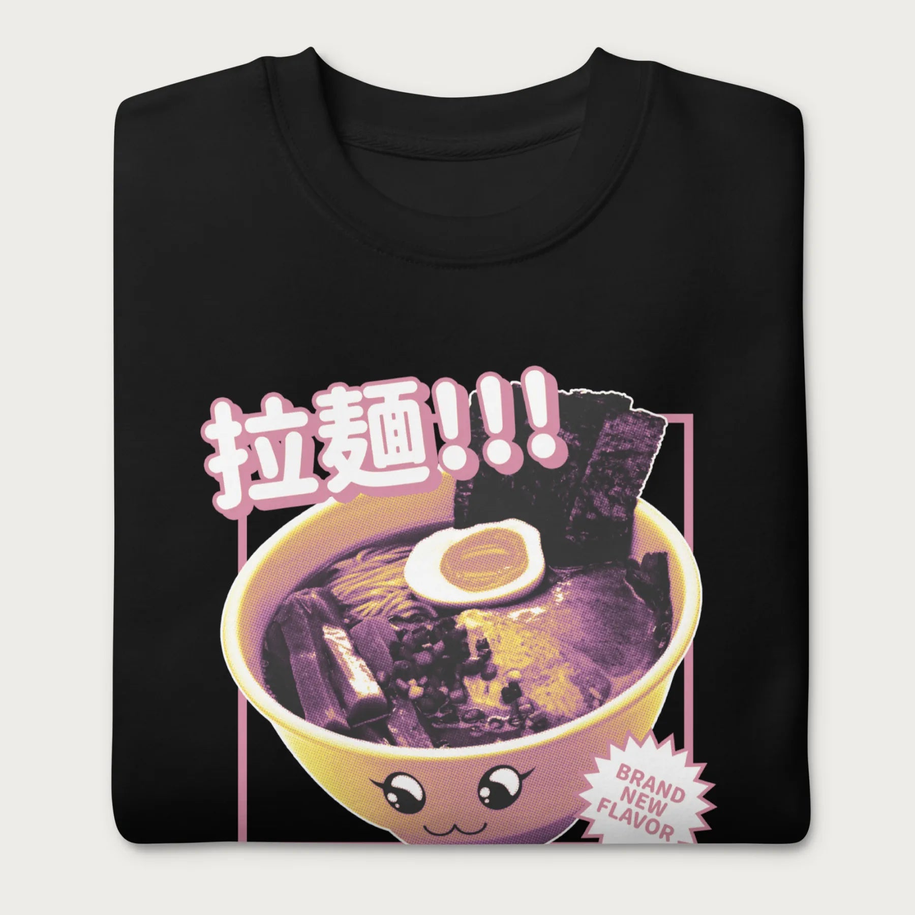 Folded black sweatshirt with Japanese text and a kawaii ramen bowl graphic.