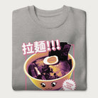 Folded light grey sweatshirt with Japanese text and a kawaii ramen bowl graphic.