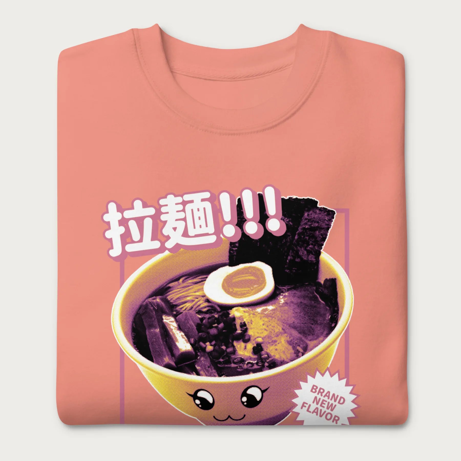 Folded light pink sweatshirt with Japanese text and a kawaii ramen bowl graphic.